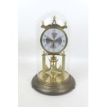 A Kundo torsion clock, on a brass effect circular base, with glass dome, dial 9cm, 19 by 30cm high