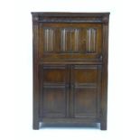 A mid 20th century dark stained oak drinks cabinet, in Old Charm style, applied linenfold decoration