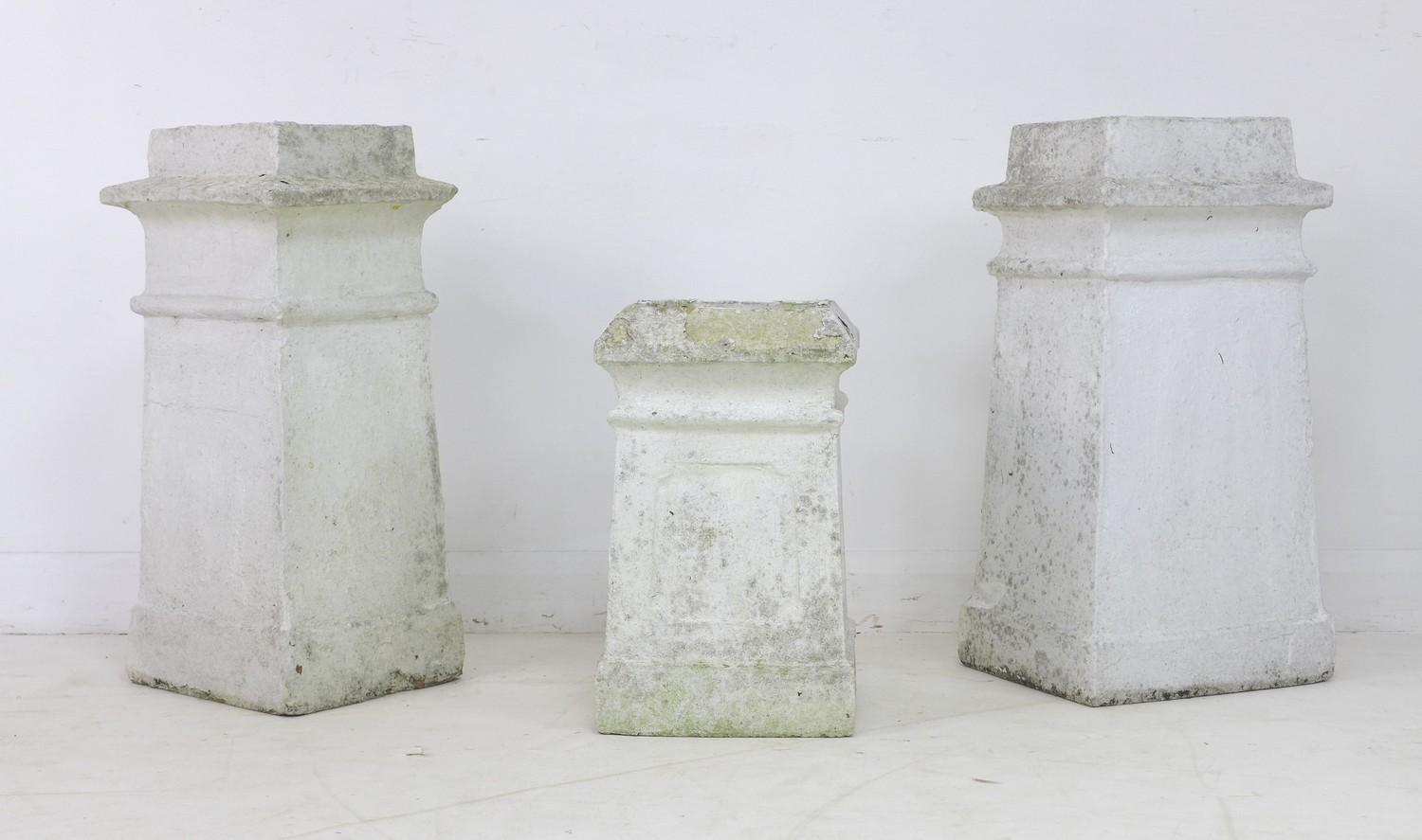 A group of three white painted chimneys, each of buff terracotta, square tapering section in