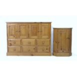 A modern pine cupboard, with two double doors over an arrangement of six drawers, with turned knobs,