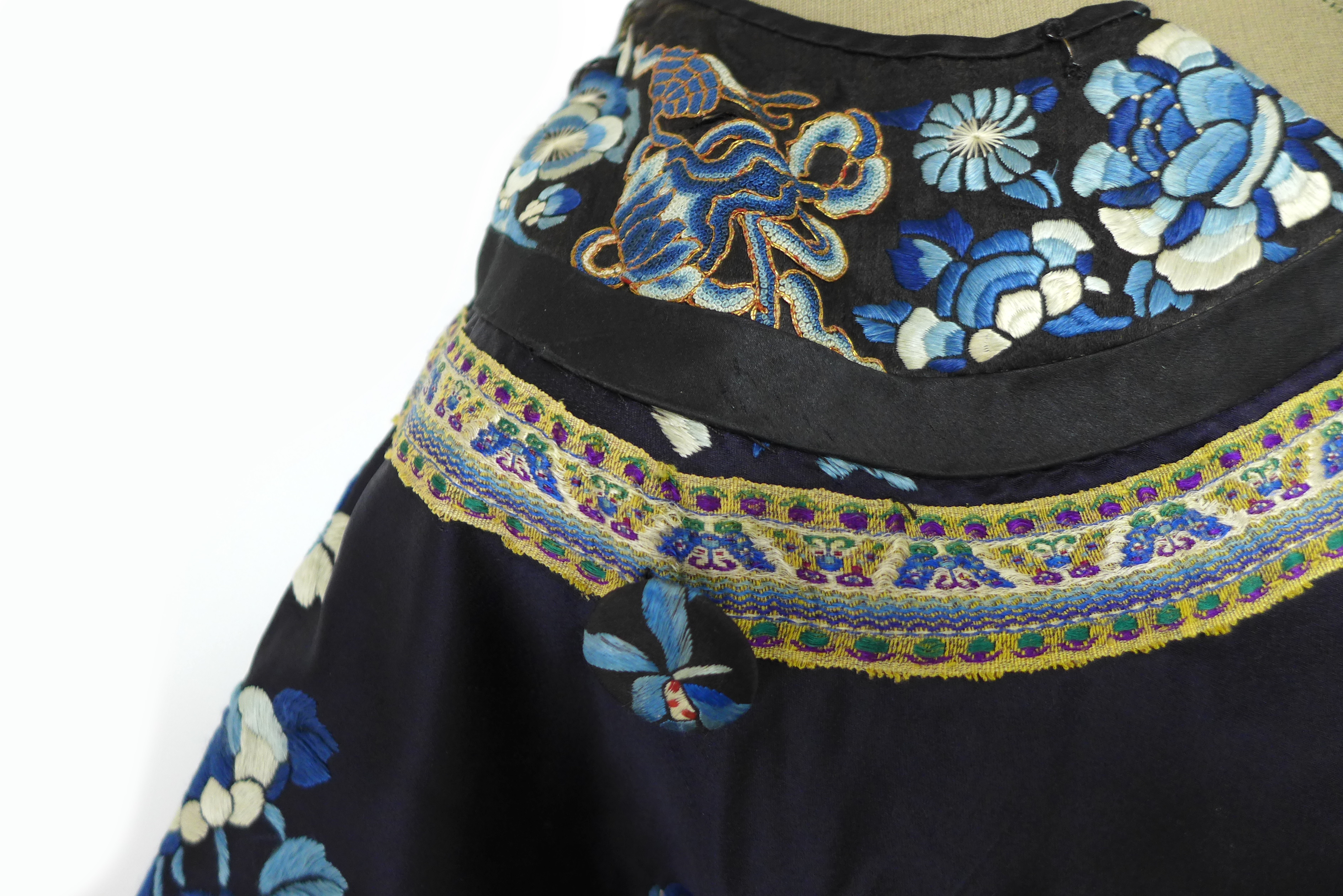 An early 20th century silk Chinese robe, with navy blue ground and intricately embroidered with - Image 10 of 34