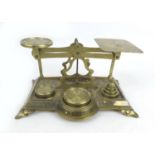 A set of Victorian brass postal scales, with six weights, with relief foliate decoration to its