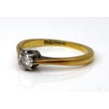 An 18ct yellow gold and platinum set diamond solitaire ring, the brilliant cut stone 0.1ct, size