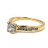 An 18ct yellow gold and diamond solitaire ring, the 0.5ct brilliant cut stone flanked on each