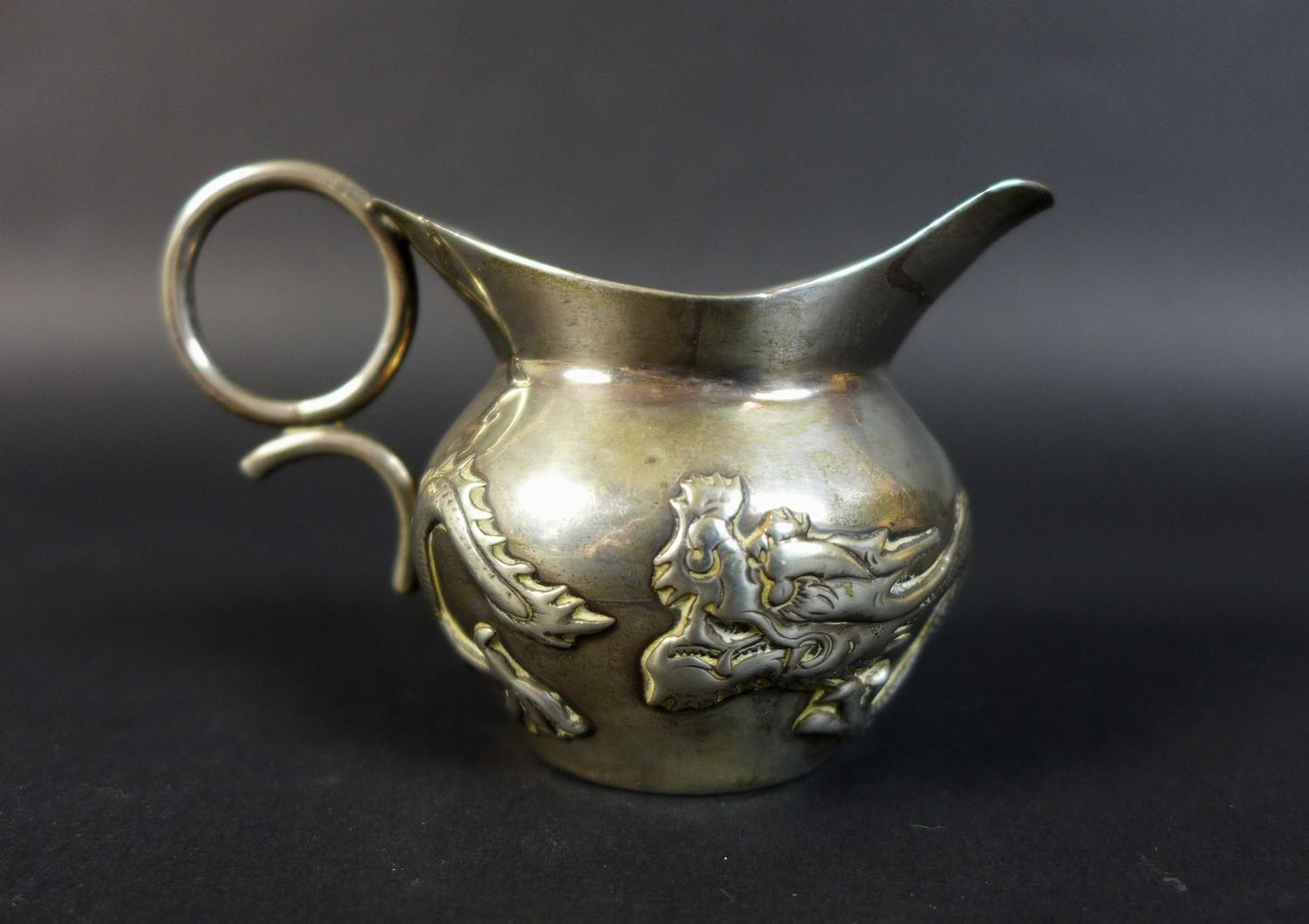 A Wang Hing and Co Chinese export silver jug, decorated with a sinuous dragon chasing his tail