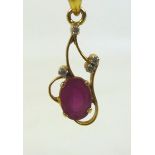 A ruby and diamond pendant with yellow metal mount, the single ruby 5.7cm by 7.cm, with four small