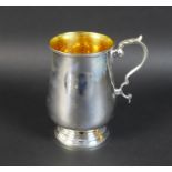 A George V silver tankard, of baluster form with scroll handle and parcel gilt interior, with rubbed