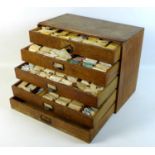 A collection of watch parts, contained within an oak five drawer table top chest, comprising a large