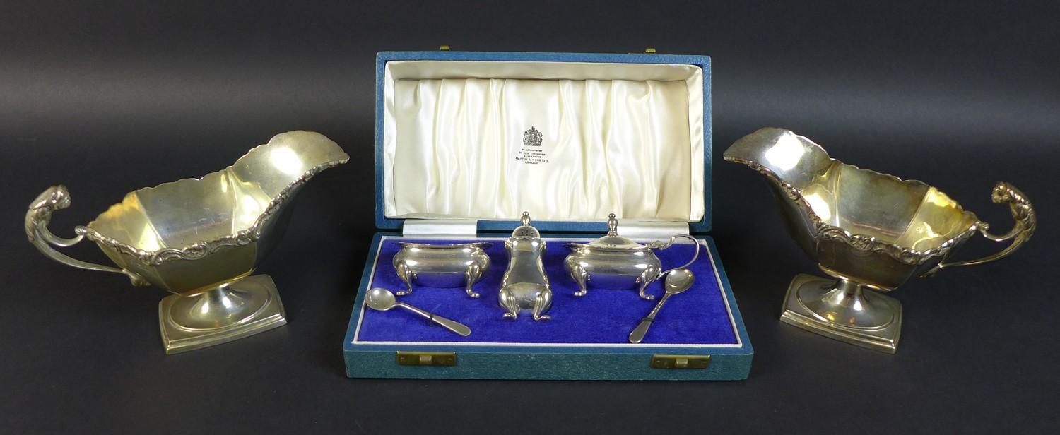 A pair of Edwardian silver sauce boats, the handles with cast jaguar heads, and scroll rim, raised