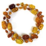 An amber necklace, with irregular form beads, including some butterscotch amber, 87cm long, gross