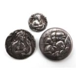 A group of three Art Nouveau silver buttons, comprising a button decorated with a woman playing a