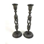A pair of Persian style wooden candlesticks,