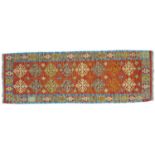 A vegetable dyed wool Choli Kelim runner, with orange ground and decorated with geometric floral