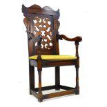 A reproduction Wainscot chair, in 17th century style, with pierced and carved back and crest, shaped