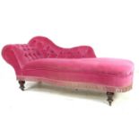 A Victorian chaise longue, with shaped arm and scroll end, upholstered in pink buttoned velvet,