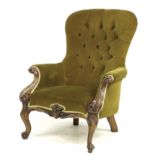 A Victorian mahogany spoon back armchair, upholstered in buttoned mustard velvet, foliate carved