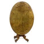 A Victorian walnut oval tilt top table, moulded edge, carved column and four cabriole legs with