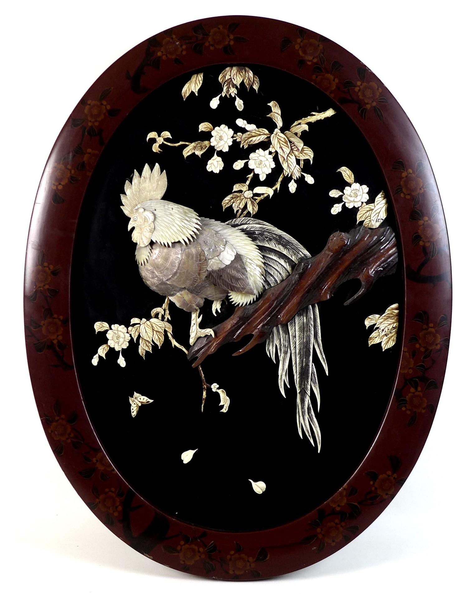 A Japanese oval wall plaque, mid to late 20th century, with relief carved and applied decoration