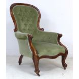 A Victorian mahogany spoon back armchair, buttoned green velvet upholstery, raised on shaped legs