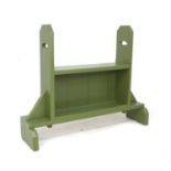 A green painted pine boot rack and seat, with pierced handles to the high sides, and open shelf