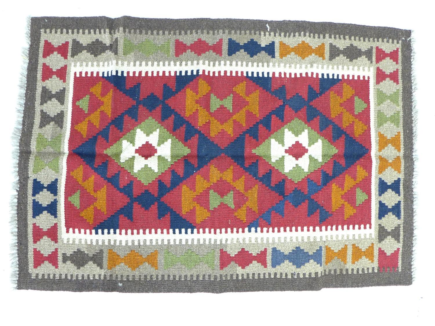 A Maimana Kelim rug, with red ground, two central lozenges and cream border, 122 by 83cm.
