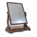 A Victorian mahogany toilet mirror, rectangular plate, shaped supports, serpentine fronted base with