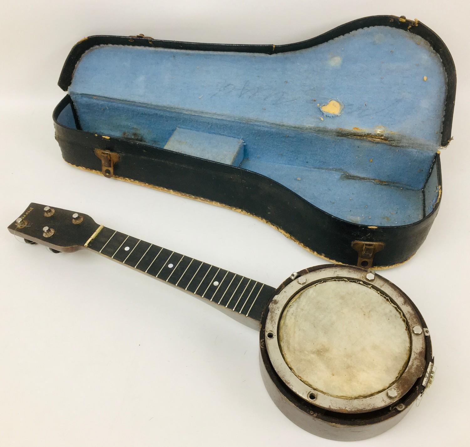 A vintage British made 1920's ukulele banjo, with hide within a wooden frame with mother of pearl