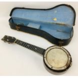 A vintage British made 1920's ukulele banjo, with hide within a wooden frame with mother of pearl