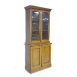 A narrow late Victorian mahogany glazed bookcase, with two glazed doors enclosing two shelves, the