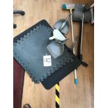 A quantity of cleaning equipment, including brushes, and some rubber floor matting.