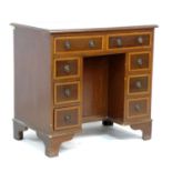 A reproduction kneehole desk, in late Georgian style, eight drawers with ring handles, brown