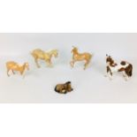A group of five Beswick horse figurines, comprising three palomino horses, one standing with
