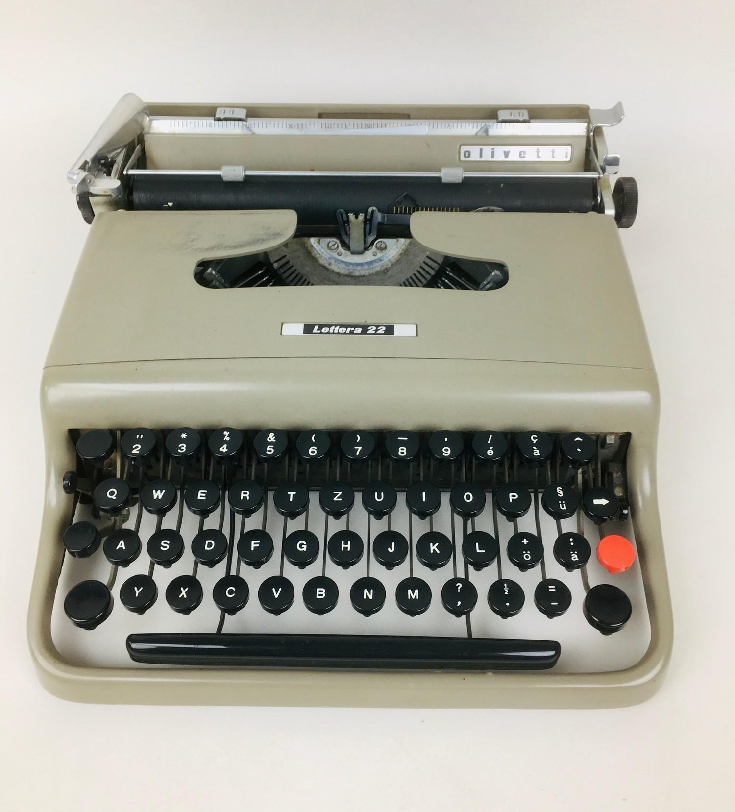 A vintage Olivetti Letter 22 typewriter, grey painted finish, with loose brown fabric cover, 30 by