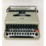 A vintage Olivetti Letter 22 typewriter, grey painted finish, with loose brown fabric cover, 30 by