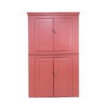 A Victorian red painted freestanding pine corner cupboard, double doors enclosing shelves to both an