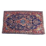 A hand knotted wool Hamadan rug, with central medallion flanked by floral sprays upon a blue ground,