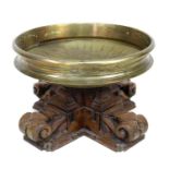 An unusual South East Asian bronze bowl and carved wood stand, the shallow bowl with decorative