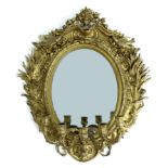 A Victorian gilt girandole mirror, cast and applied oval composition frame decorated with two