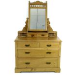 An Edwardian pine dressing chest, mirror with trinket drawers over two short and two long drawers,