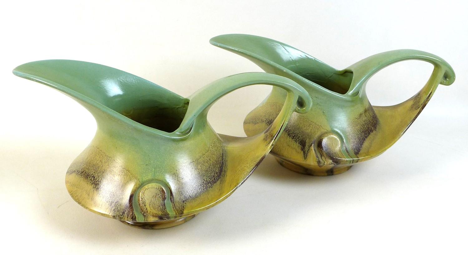 A pair of Dutch Art Deco jugs of squat curvilinear design with slip glaze in pale green, buff and