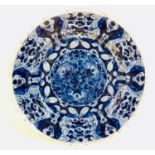 An 18th century Dutch blue and white tin glazed charger, decorated with three flower heads to the