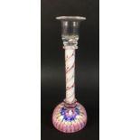 A glass candlestick with candy twist stem in white red and clear glass and millefiore paperweight