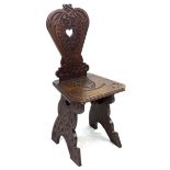 A mid 20th century stained oak hall chair, the seat and back carved with a lion crest and motto '