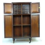 A mid 19th century mahogany cupboard, two double cupboard doors with brass edging, the smaller upper