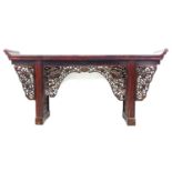 A late 19th century Chinese altar table, the long surface with upturned ends, decorative pierced and