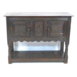 A Jacobean style oak small sideboard, with carved decoration and chip carved ends, swivel toggles to