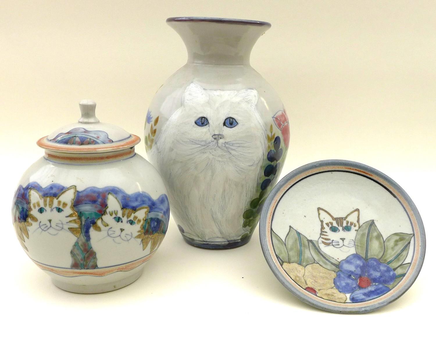 A group of Highland Stoneware pottery depicting cats, comprising a vase signed HEW, 32cm high, three