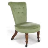 An early 19th century rosewood nursing or prayer chair, later green velour upholstery, raised on