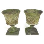 Two stoneware garden urn planters decorated with a woven rush effect with associated bases, urns, 40