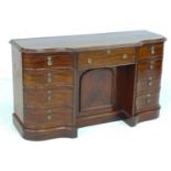 A Victorian mahogany knee hole desk, of serpentine, breakfront outline, with six drawers and two